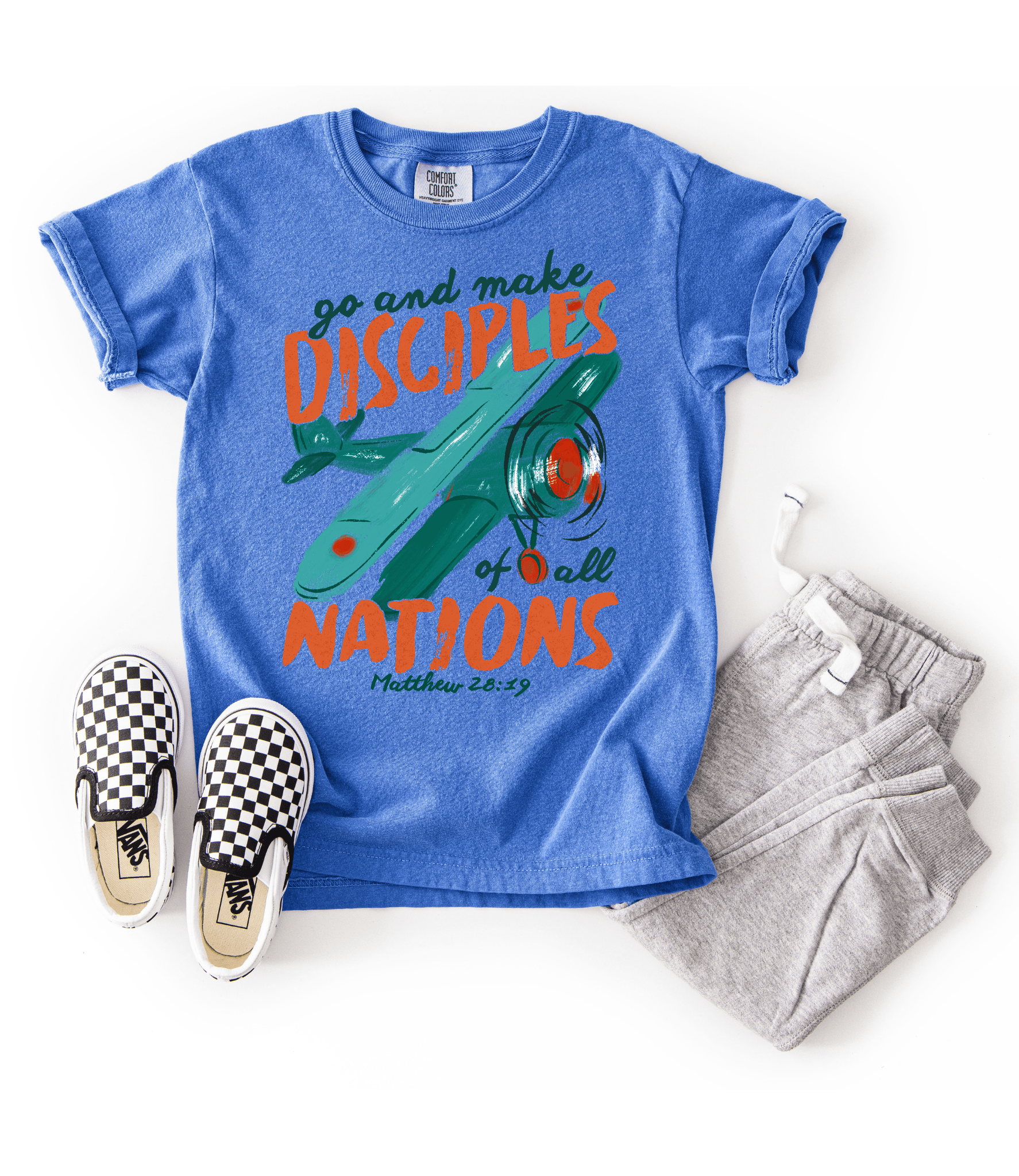 Youth Flo Blue Christian T-shirt styled with gray joggers and checkerboard slip-on shoes featuring a colorful Great Commission airplane graphic.