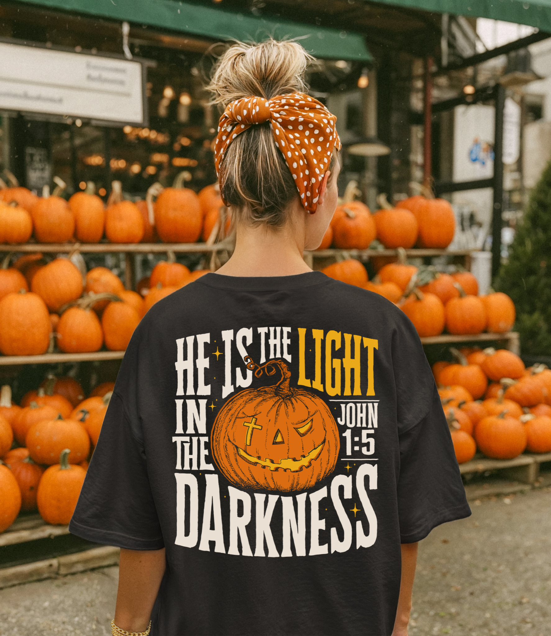 back of model wearing "He is the light in the darkness" jack-o-lantern design