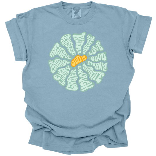 Ice Blue t-shirt with a circular, retro-inspired design featuring the attributes of God, including Faithful, Merciful, Eternal, Good, Infinite, In Control, and More, with the text "God Is" in vibrant orange at the center.