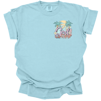 t-shirt with a small beach-themed design featuring the text "God Is My Refuge" with palm trees, waves, and pastel accents.