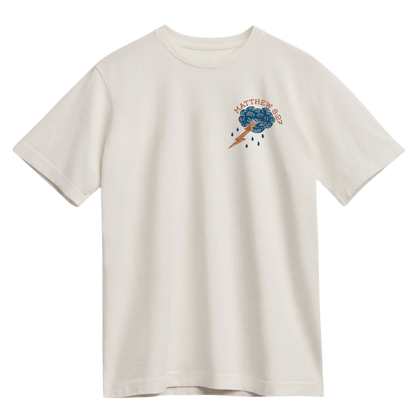 Ivory t-shirt with a small storm cloud and lightning bolt graphic, featuring the text "Matthew 8:27" in rust and navy tones.