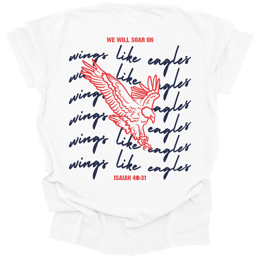 White t-shirt with a large eagle illustration and the words "We Will Soar on Wings Like Eagles" in bold navy script, inspired by Isaiah 40:31.